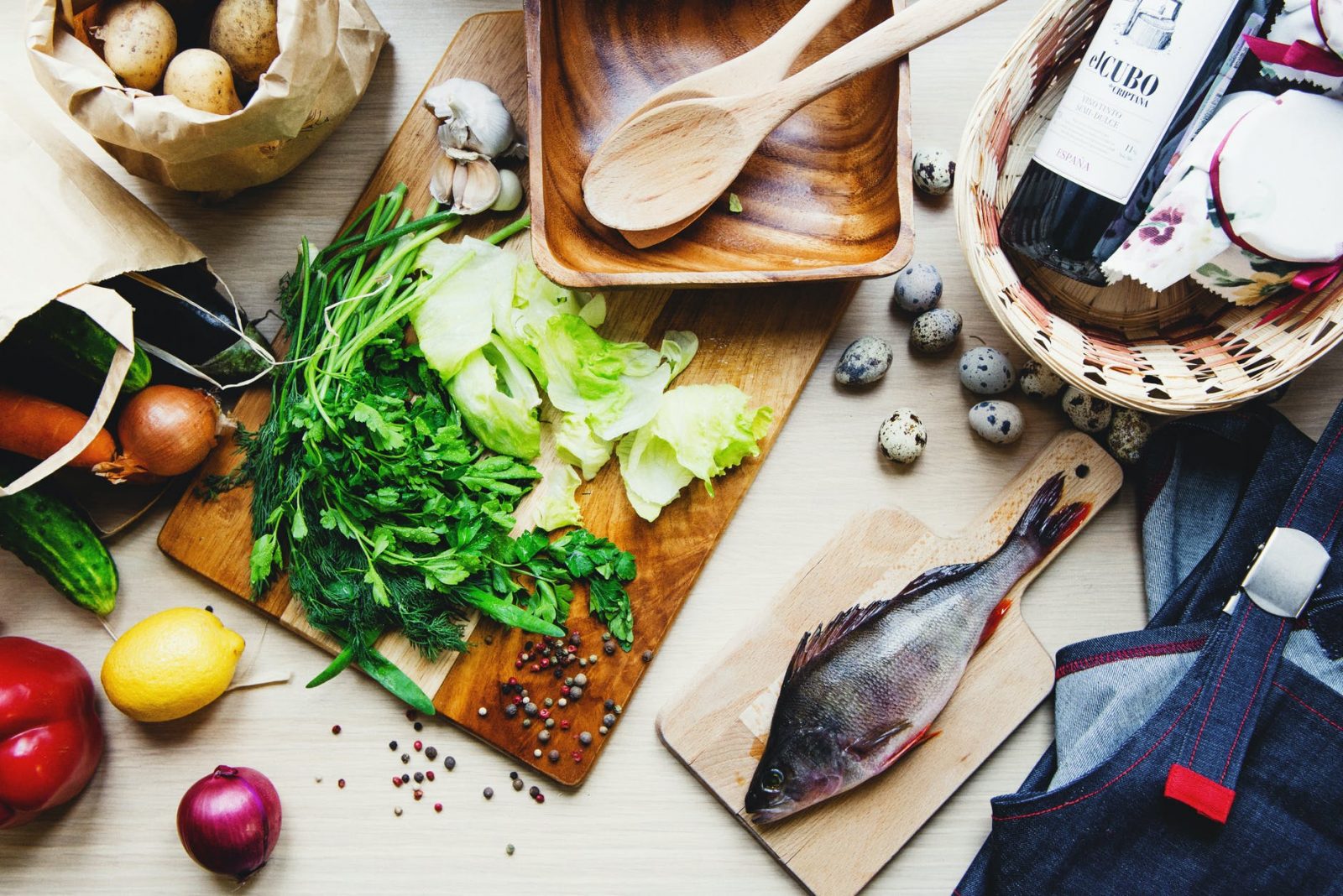 fresh vegetables and fish on cutting board in kitchen